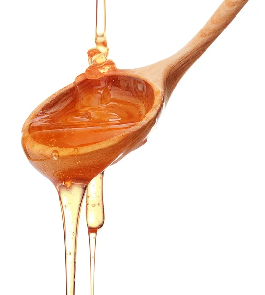 Honey dripping from wooden spoon — Stock Photo © natika 108744234