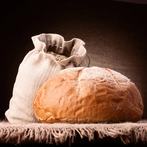 Пшеничный хлеб и мешок муки натюрморт — стоковое фото