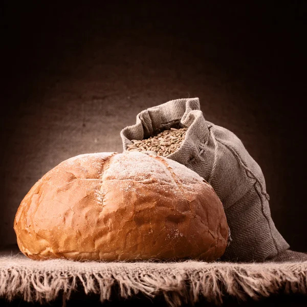 Пшеничный хлеб и мешок муки натюрморт — стоковое фото