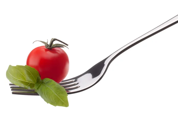 Hoja de albahaca y tomate cherry en tenedor —  Fotos de Stock