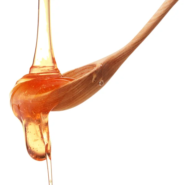 Miel goteando de un tarro de miel de madera aislado sobre fondo blanco — Foto de Stock