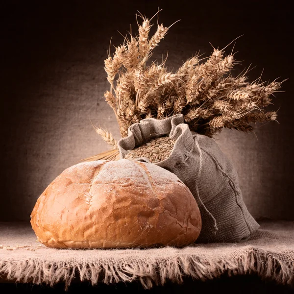 Pane, farina sacco e orecchie grappolo natura morta — Foto Stock