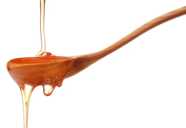 Miel goteando de un tarro de miel de madera aislado sobre fondo blanco — Foto de Stock