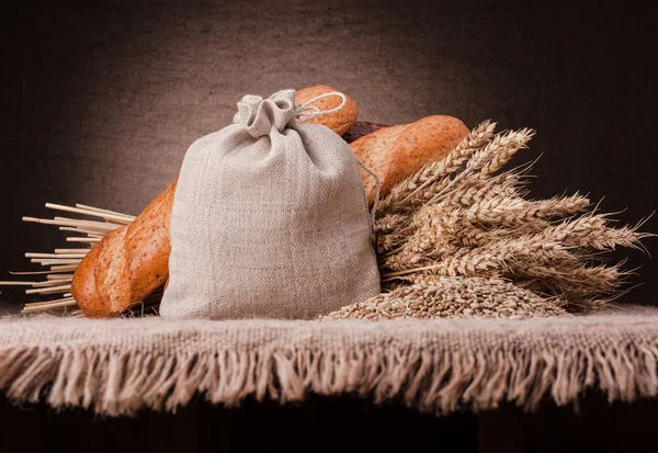 Bread, flour sack and ears bunch still life — Stock Photo, Image