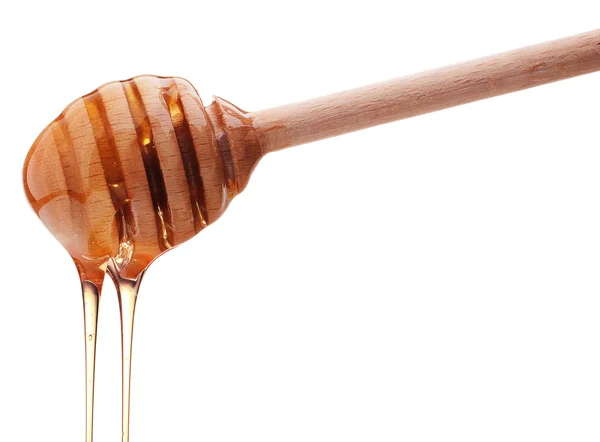 Miel goteando de un tarro de miel de madera aislado en la espalda blanca — Foto de Stock