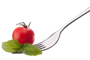 Beyaz backgrou izole çatal üzerinde kiraz domates ve fesleğen yaprağı