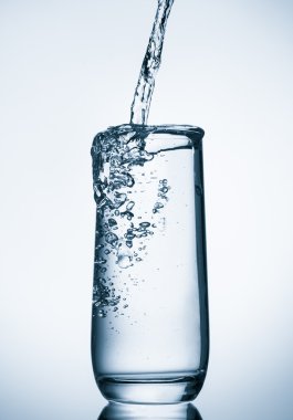 üzerinde mavi arka plan cam içine dökülen su