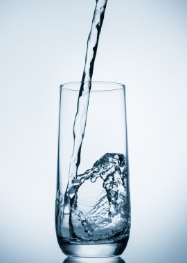 üzerinde mavi arka plan cam içine dökülen su