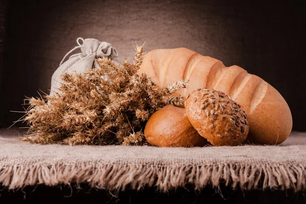 Pão, saco de farinha e orelhas bando ainda vida — Fotografia de Stock