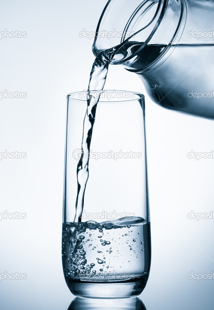 Pouring water from glass pitcher on blue background Stock Photo by ©natika  43995335