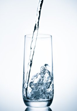 üzerinde mavi arka plan cam içine dökülen su