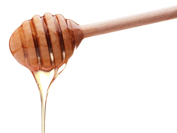 Honey dripping from a wooden  dipper — Stock Photo, Image
