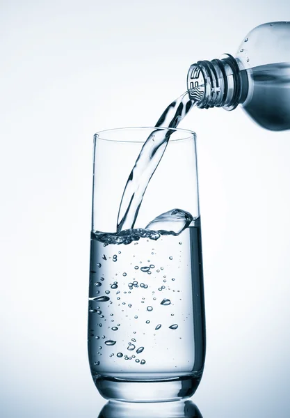Wasser aus Flasche ins Glas gießen — Stockfoto