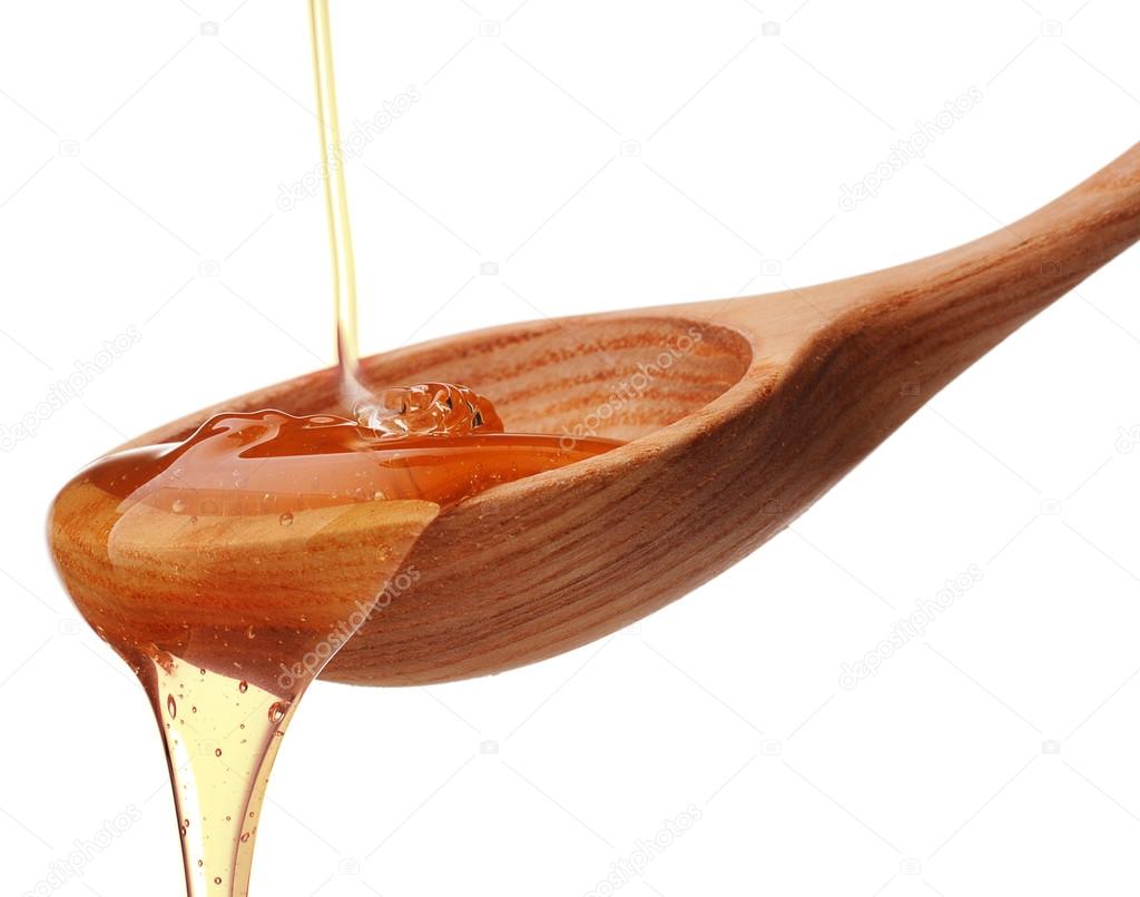 Honey dripping from wooden spoon