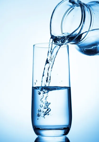 Wasser aus Glaskanne gießen — Stockfoto