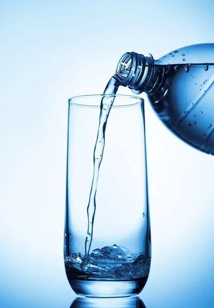 Wasser aus Flasche ins Glas gießen — Stockfoto