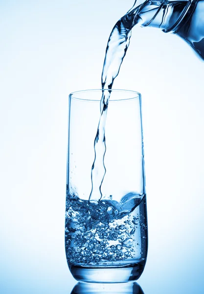 Wasser aus Glaskanne gießen — Stockfoto