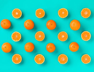 Meyve taze mandalina dilimleri üzerinde mavi arka plan deseni. Düz yatıyordu, en iyi görünüm. Pop sanat tasarım, yaratıcı yaz konsepti. Minimal tarzda narenciye yarısı. Mandalina.