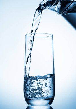 cam sürahi mavi zemin üzerine su dökerek