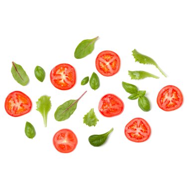 Domates dilimleri ve salata yapraklarından oluşan yaratıcı bir düzen. Düz yerde, üst tarafta. Yemek konsepti. Beyaz arka planda izole edilmiş sebzeler. Gıda bileşenleri kalıbı.