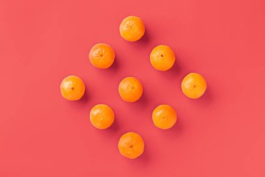Canlı mercan arka plan taze portakal mandalina veya mandalina meyve desen. Düz yatıyordu, üstten bak. Pop art tasarımı, yaratıcı yaz konsepti. Minimal tarzda narenciye.