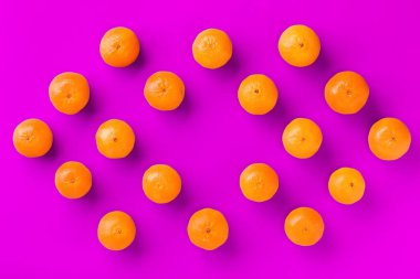 Leylak arka plan üzerinde taze portakal mandalina veya mandalina Meyve desen. Düz yatıyordu, üstten bak. Pop art tasarımı, yaratıcı yaz konsepti. Minimal tarzda narenciye.