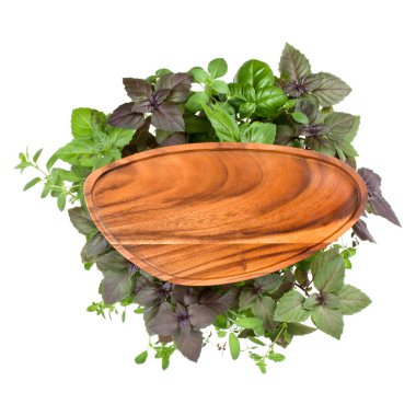 Boş ahşap plaka üzerinde çeşitli fesleğen bitki yaprakları arka plan. Sağlıklı gıda kavramı. Kopya alanı ile üstten görünüm.