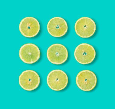 Mavi arka planda limon dilimlerinin meyve deseni. Düz yatış, üst görünüm.