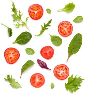 Domates dilimleri ve salata yapraklarından oluşan yaratıcı bir düzen. Düz yerde, üst tarafta. Yemek konsepti. Beyaz arka planda izole edilmiş sebzeler. Gıda bileşenleri kalıbı.