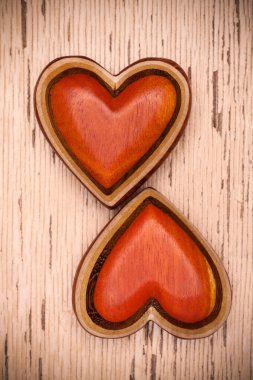 Rustik ahşap zemin üzerine iki ahşap kalp. Valentines gün kavramı. Aşk sembolü. Tebrik kartı.