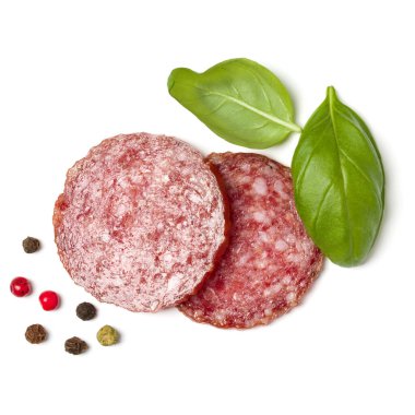 Beyaz arka plan closeup izole salam dilimleri. Sosis ve fesleğen üst görünümü bırakır.