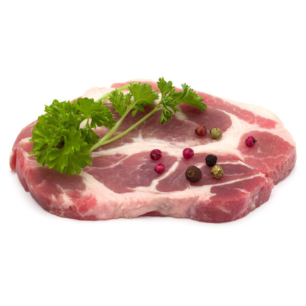 Raw pork neck chop meat with parsley herb leaves and peppercorn spices garnish isolated on white background cutout