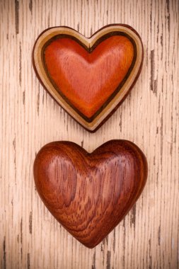 Rustik ahşap zemin üzerine iki ahşap kalp. Valentines gün kavramı. Aşk sembolü. Tebrik kartı.