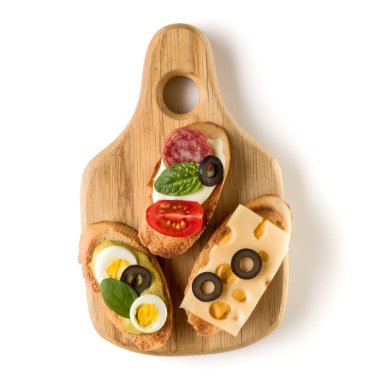 Açık yüzlü sandviç kanepe veya crostini beyaz arka plan closeup izole bir ahşap hizmet gemide. Üstten görünüm.