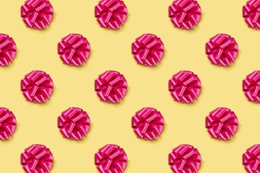 seamless pattern of colorful festive bows pattern isolated on yellow background