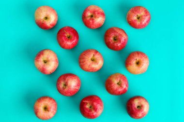 Mavi arka planda kırmızı elmanın meyve deseni. Düz yerde, üst tarafta. Pop sanat tasarımı, yaratıcı yaz konsepti. Gıda arkaplanı.