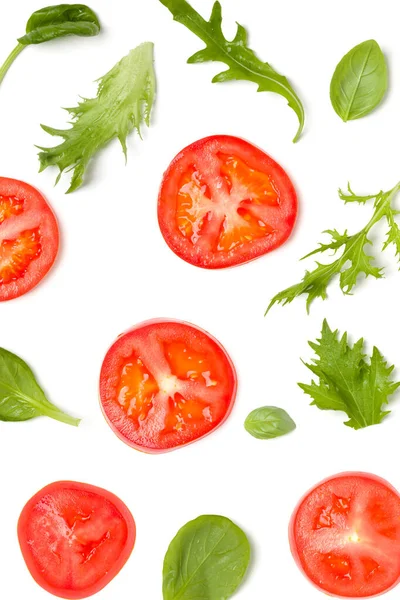 Vegetables background made of tomato slices and lettuce salad leaves. Flat lay, top view. Food concept. Vegetables isolated on white background. Food ingredients pattern.