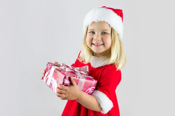 Schönes Mädchen in roter Neujahrsmütze mit Geschenk — Stockfoto