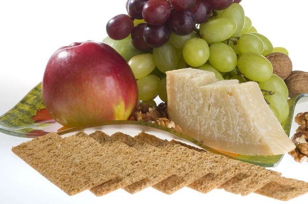 Jabłka, winogron, orzechy i ser, leżący na talerzu. — Zdjęcie stockowe