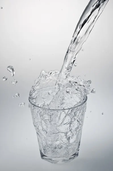 Water stream being poured into a glass Stock Picture