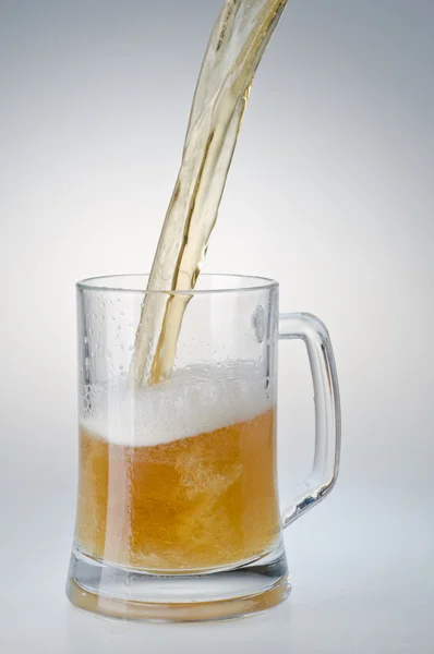 Beer being poured into a mug from a bottle — Stock Photo, Image