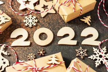 Mutlu yıllar 2022. Ahşap Noel ya da tahta kahverengi arka planda yeni yıl süslemeleri. ECO dekorasyonları