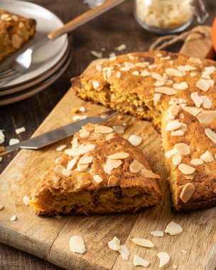 Ev yapımı, bademli balkabağı turtası ve tahta servis tahtasının üzerinde çikolata. Sonbahar geleneksel tatlı hamur işleri