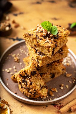 Çikolatalı ve cevizli bal kabağı sarışınlar. Brownie turtası, karanlık mutfak arka planında bir tabağa dilimler. Şükran Günü için pişirme