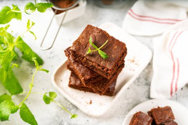 Çikolatalı kek, arka planda beyaz bir tabakta dilimler. Ev yapımı sarışınlar geleneksel Amerikan tatlıları yakın plan.