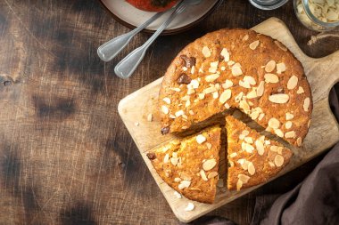 Ev yapımı, bademli balkabağı turtası ve tahta servis tahtasının üzerinde çikolata. Sonbahar geleneksel tatlı hamur işleri