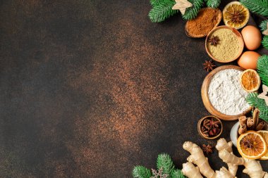 Koyu renk mutfak arka planında zencefilli kurabiye malzemeleri. Noel ya da Yeni Yıl tatili için çeşitli yiyecekler üst düzeyde pişirme