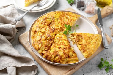 Frittata ya da seramik tabakta hafif bir mutfak arka planında patates turtası. Geleneksel İtalyan lezzetli ev yapımı yumurta tabağı mutfak masasında.