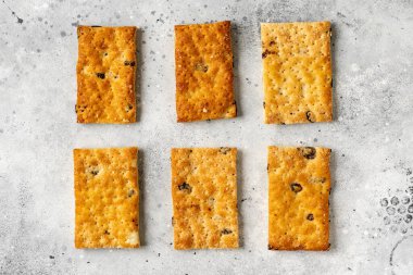 Kuru üzümlü tatlı açık gri mutfak arka planına yayılır. Lezzetli ev yapımı tatlı poğaça yakın plan.