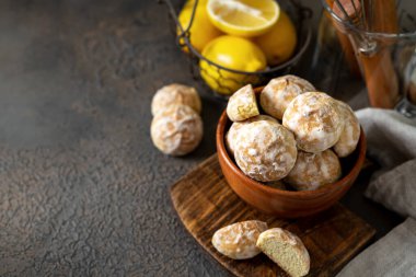 Koyu bir mutfak arka planında ahşap bir kasede limonlu zencefilli kek. Lezzetli ev yapımı kurabiyeler. Yakın plan.